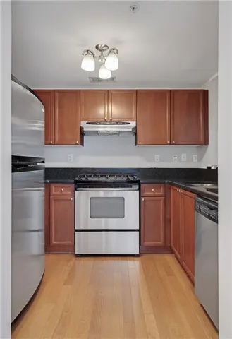 a kitchen with granite countertop a sink stove and microwave