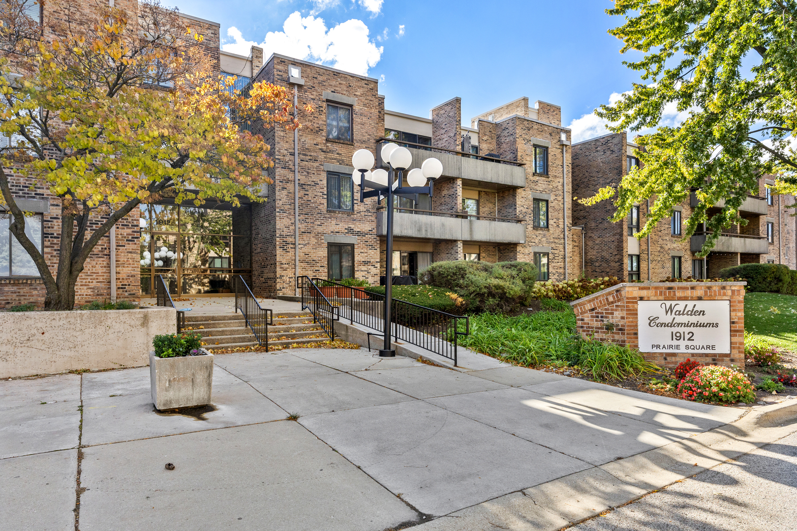 1912 Prairie Square, Unit 209A Schaumburg, IL 60173 - Photo 1 of 26 a view of a building with a garden and pathway