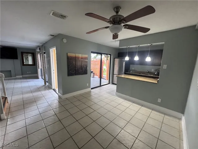 a view of an empty room and a ceiling fan