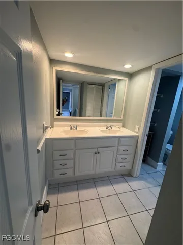 a bathroom with a double vanity sink mirror and bathtub