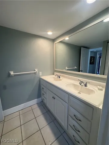 a bathroom with a double vanity sink a mirror and a