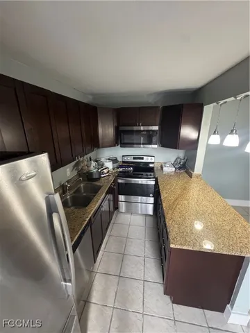 a kitchen with stainless steel appliances a stove a sink and a refrigerator