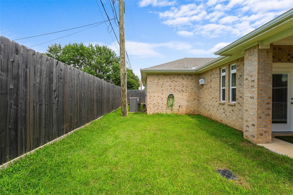 3807 Winding Road Arlington, TX 76016 - Photo 22 of 23 Side yard featuring a privacy fence, green lawn, and brick exterior