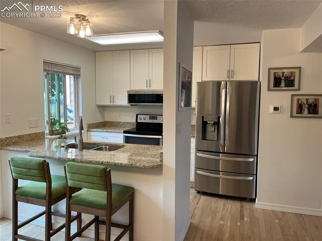 a kitchen with stainless steel appliances granite countertop a refrigerator and a stove top oven