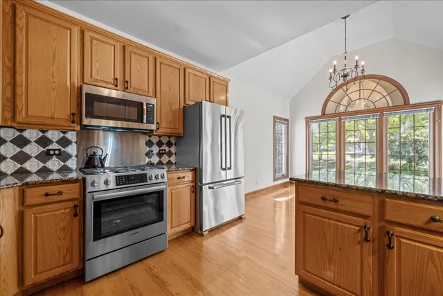a kitchen with stainless steel appliances granite countertop a stove a refrigerator and a sink