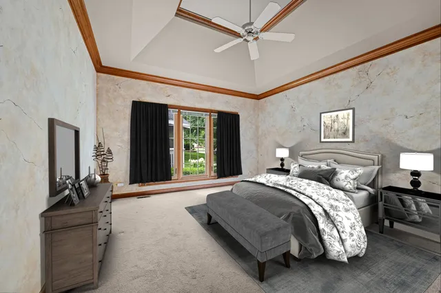 a bedroom with a large bed and a chandelier fan