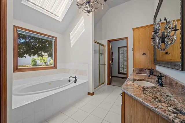 a spacious bathroom with a granite countertop tub a sink and a large mirror