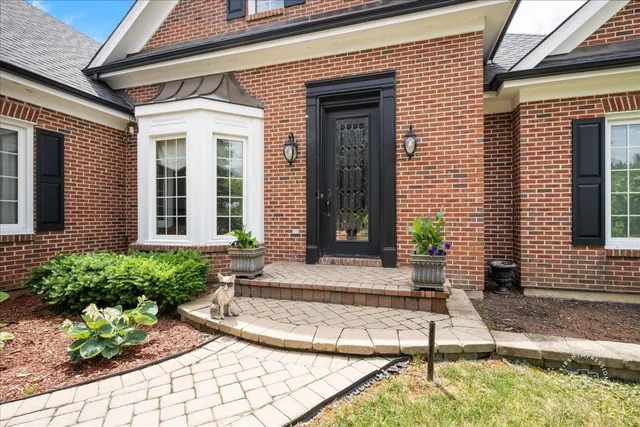 a view of a house with small yard plants and wooden fence
