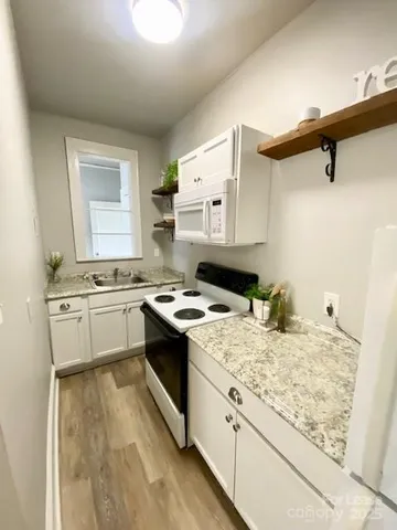 a kitchen with a stove and white cabinets