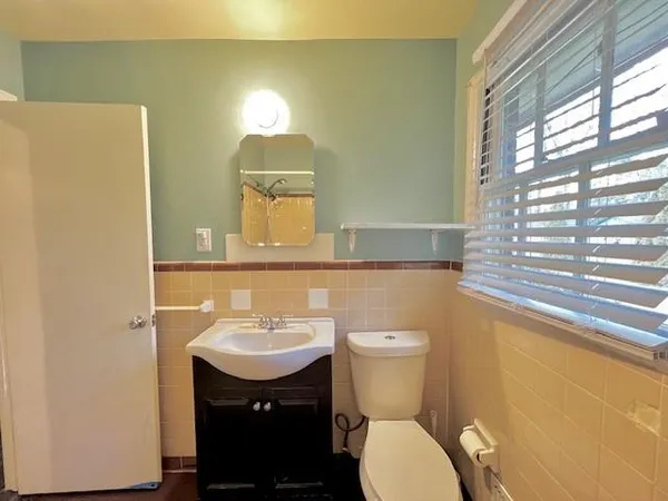 a bathroom with a sink toilet and a mirror