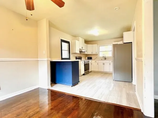 a kitchen with stainless steel appliances granite countertop a refrigerator a stove and a wooden floors