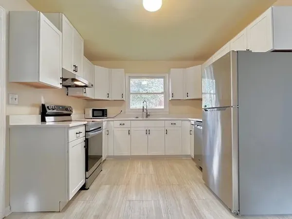 a kitchen with white cabinets and white appliances