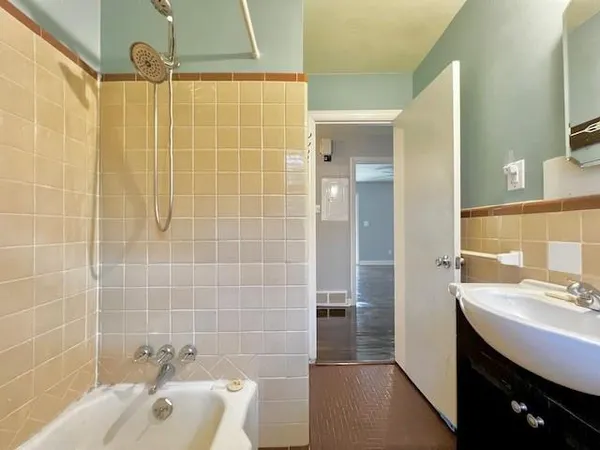 a bathroom with a sink a toilet a mirror and shower