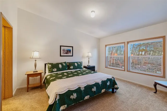 a bedroom with a bed a lamp and a large window