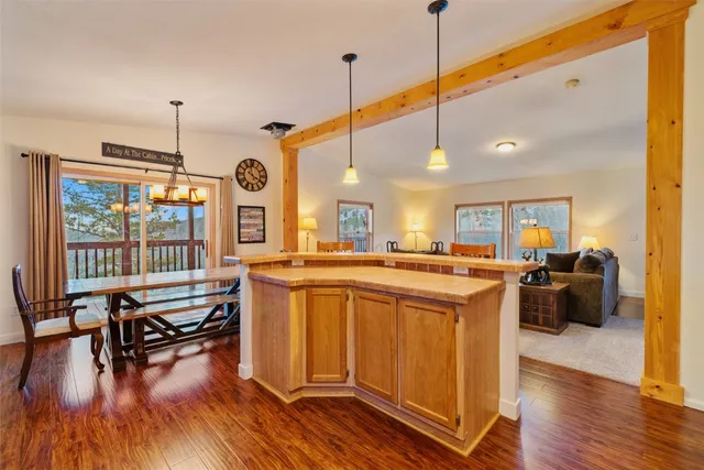 a kitchen with stainless steel appliances granite countertop a stove a sink dishwasher and a dining table with wooden floor