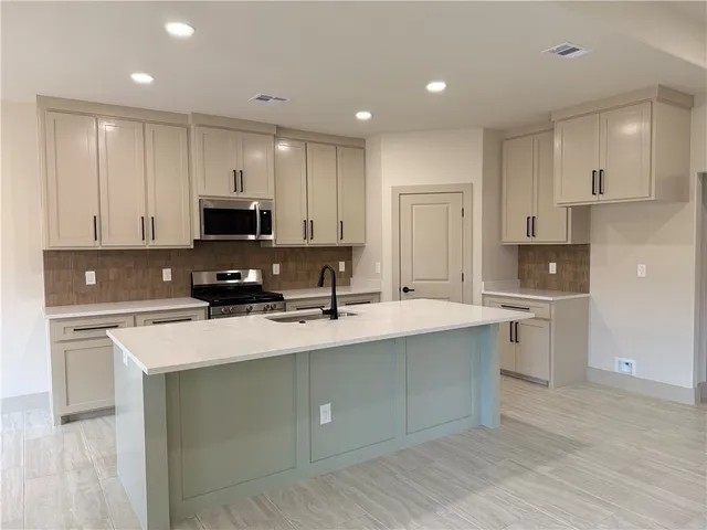 a kitchen with appliances a sink cabinets and a counter top space
