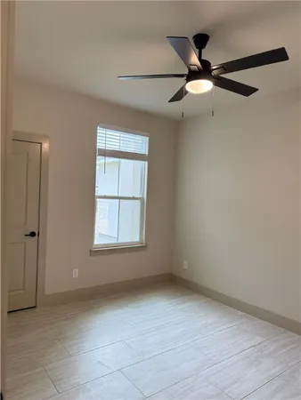an empty room with fan and windows