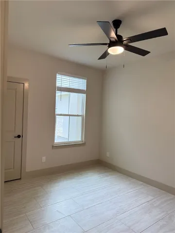 an empty room with fan and windows
