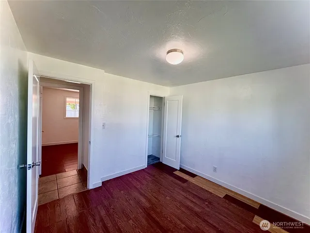 an empty room with wooden floor and closet