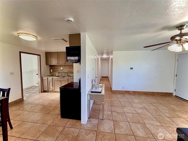 a living room with stainless steel appliances kitchen island granite countertop a refrigerator and cabinets