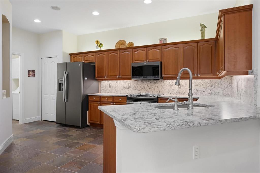 1807 San Trovaso Way Venice, FL 34285 - Photo 13 of 61 a kitchen with stainless steel appliances granite countertop a sink refrigerator and cabinets