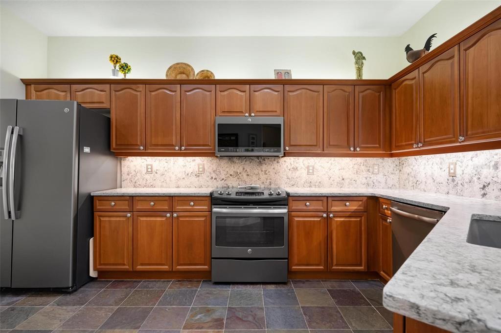 1807 San Trovaso Way Venice, FL 34285 - Photo 14 of 61 a kitchen with stainless steel appliances granite countertop a refrigerator and a stove top oven