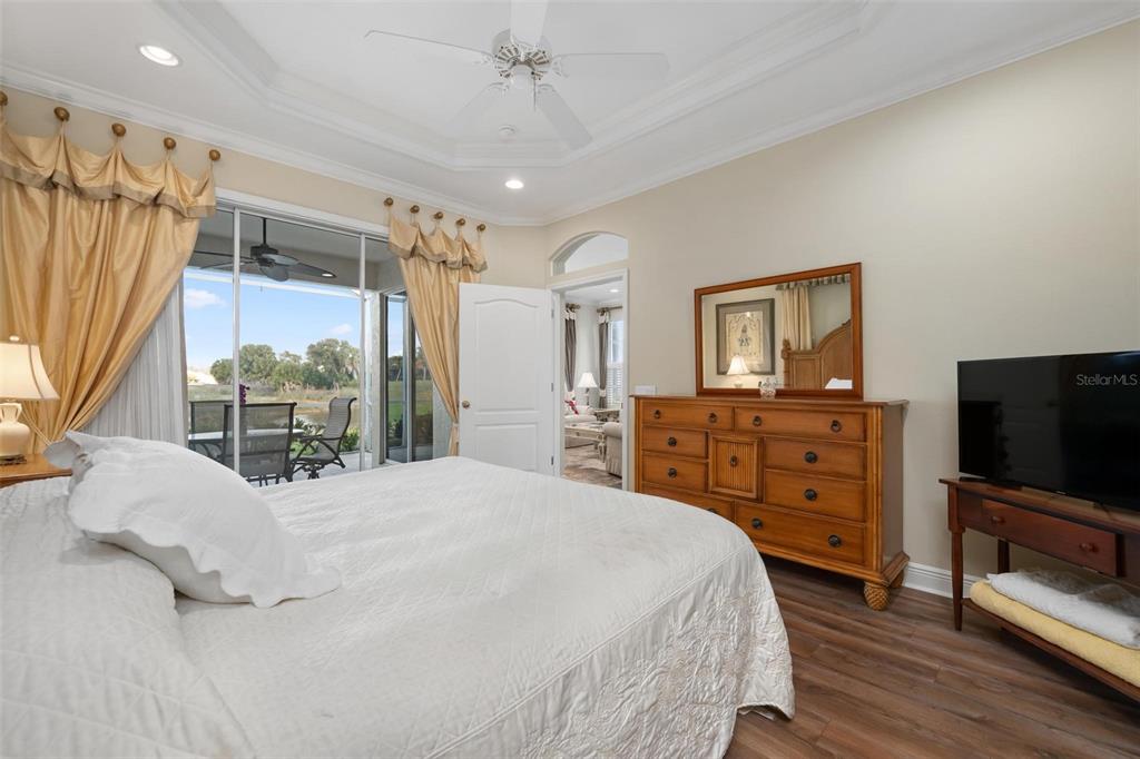 1807 San Trovaso Way Venice, FL 34285 - Photo 21 of 61 a bedroom with a large bed and a flat tv screen on dresser