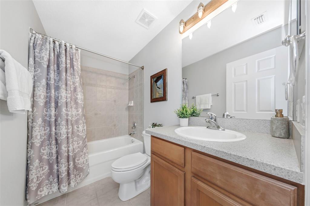 3716 Janus Way Palm Harbor, FL 34685 - Photo 43 of 69 a bathroom with a granite countertop sink a toilet and shower