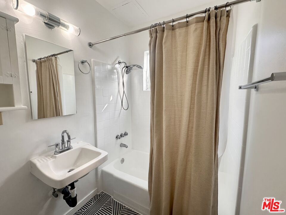 1420 17th Street, Unit 3 Santa Monica, CA 90404 - Photo 12 of 14 a bathroom with a sink a mirror a bathtub and shower