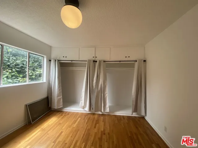 a view of a room with wooden floor and a window