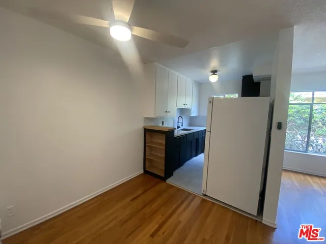 a kitchen with wooden floor and cabinets