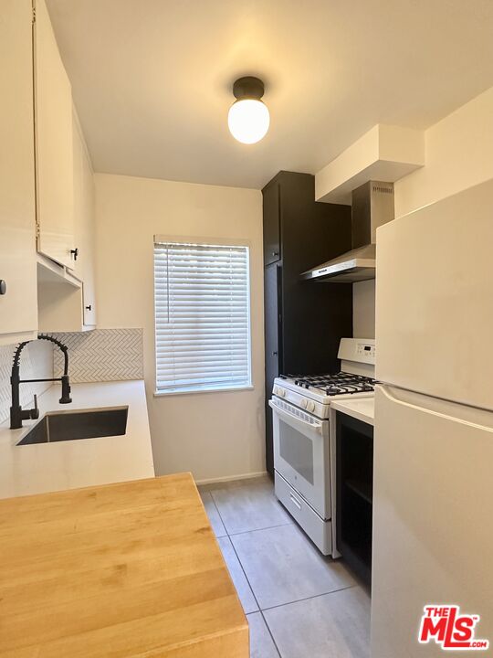 1420 17th Street, Unit 3 Santa Monica, CA 90404 - Photo 8 of 14 a kitchen with a stove top oven and sink