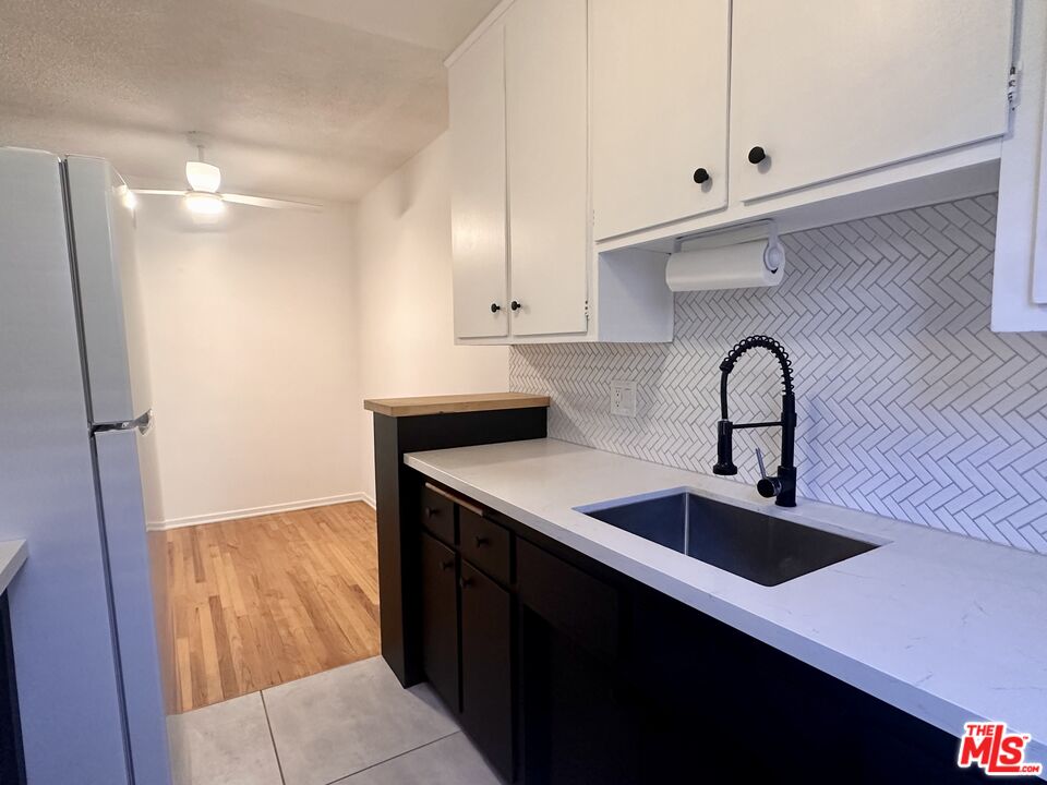1420 17th Street, Unit 3 Santa Monica, CA 90404 - Photo 9 of 14 a kitchen with granite countertop a sink and cabinets