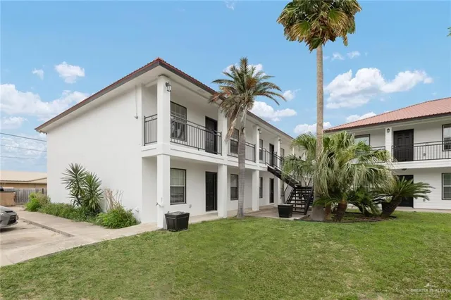 a front view of a house with a yard and potted plants