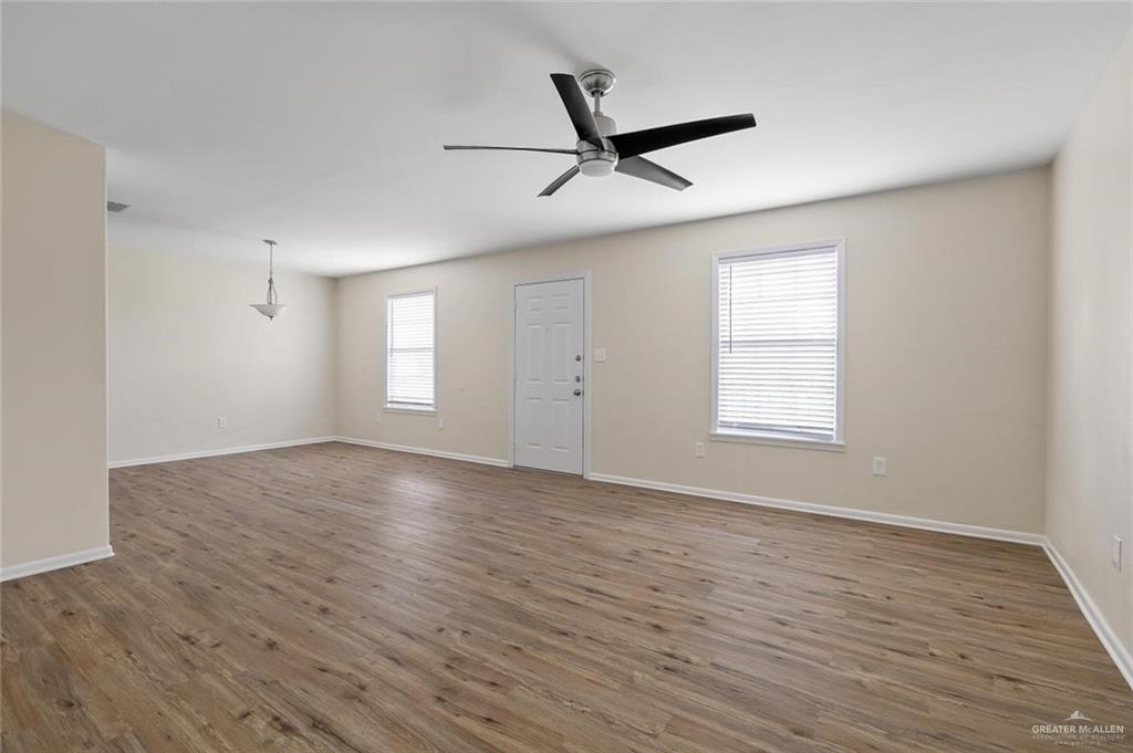 1105 West Stubbs Street, Unit 3 Edinburg, TX 78539 - Photo 4 of 15 an empty room with wooden floor fan and windows