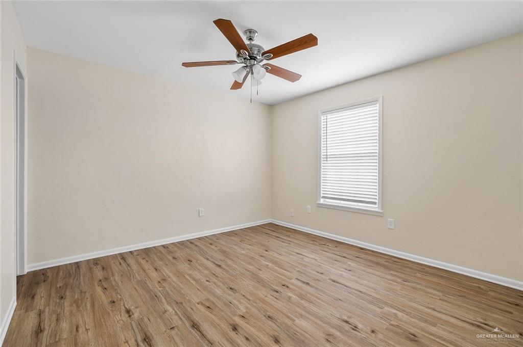 1105 West Stubbs Street, Unit 3 Edinburg, TX 78539 - Photo 9 of 15 an empty room with wooden floor fan and windows