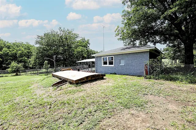 a view of a house with backyard and trees