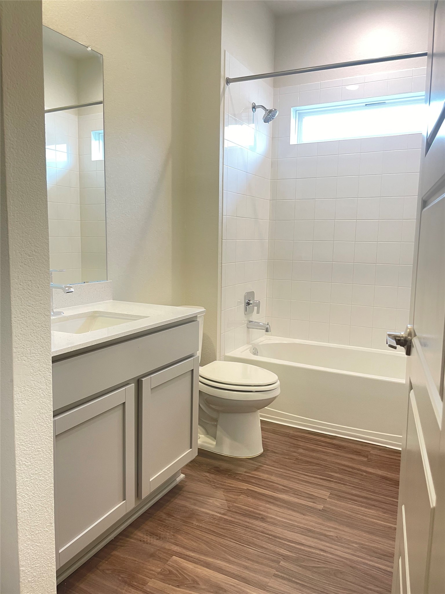 5128 Vanner Path Georgetown, TX 78626 - Photo 15 of 20 Bathroom featuring a white vanity with integrated sink, chrome fixtures, white subway tile shower surround, and vinyl flooring