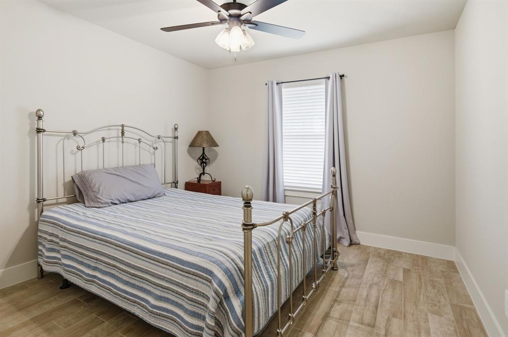 112 Monarch Lane Poolville, TX 76487 - Photo 21 of 37 Room featuring neutral wall tones, wood-finish flooring, and a ceiling fan with integrated lighting