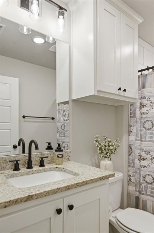 112 Monarch Lane Poolville, TX 76487 - Photo 25 of 37 Bathroom featuring a light-toned vanity with a built-in sink, dark-toned faucet, and a speckled countertop