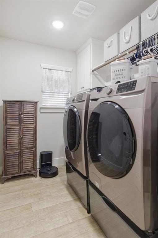 112 Monarch Lane Poolville, TX 76487 - Photo 27 of 37 Dedicated laundry space featuring a window with blinds, wood-finish flooring, and upper cabinetry with shelving