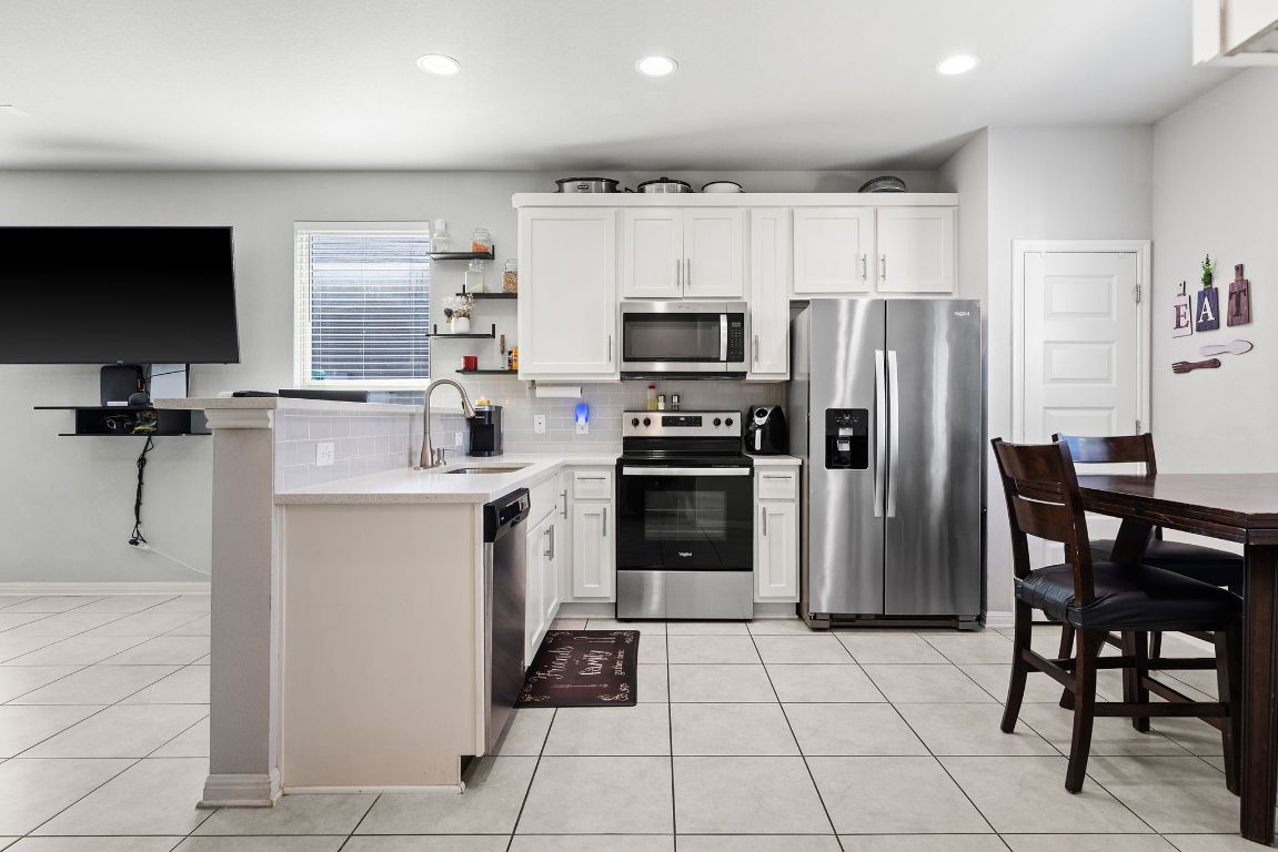 241 El Dorado Road Jarrell, TX 76537 - Photo 9 of 26 a kitchen with stainless steel appliances a refrigerator stove microwave and cabinets