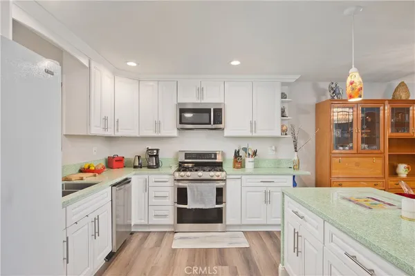 a kitchen with stainless steel appliances granite countertop a stove and cabinets