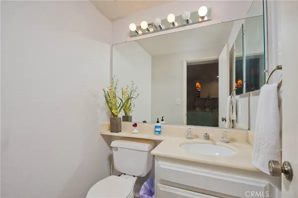 a bathroom with a sink a toilet and mirror