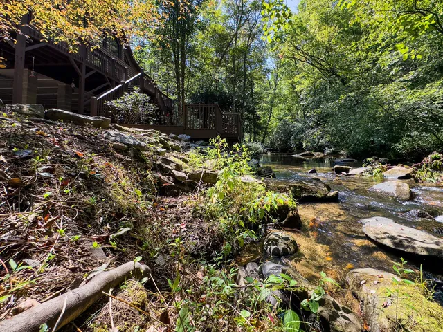 a backyard of a house with lots of green space and lake view