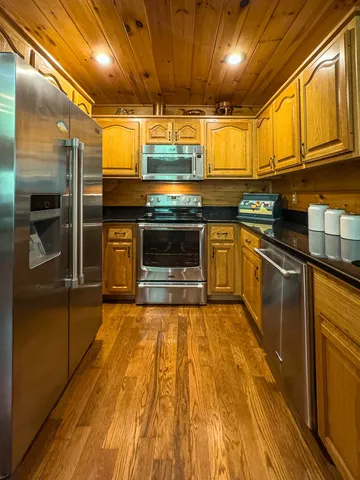 a kitchen with stainless steel appliances granite countertop a stove a sink and a microwave