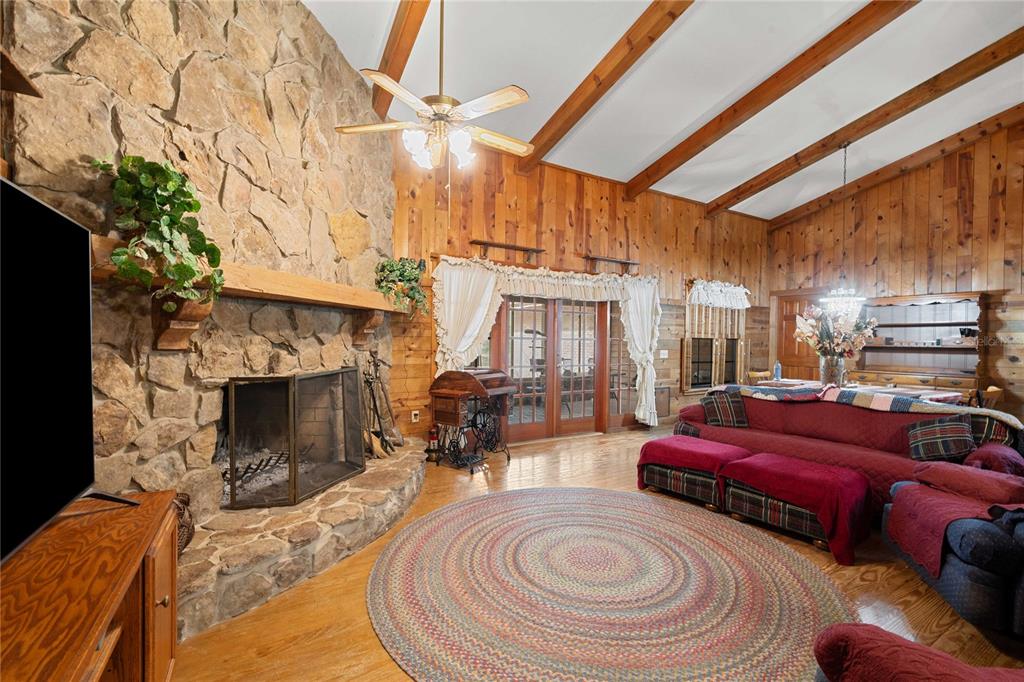 17055 Sweetwater Road Dade City, FL 33523 - Photo 21 of 53 a living room with furniture a fireplace and a large window