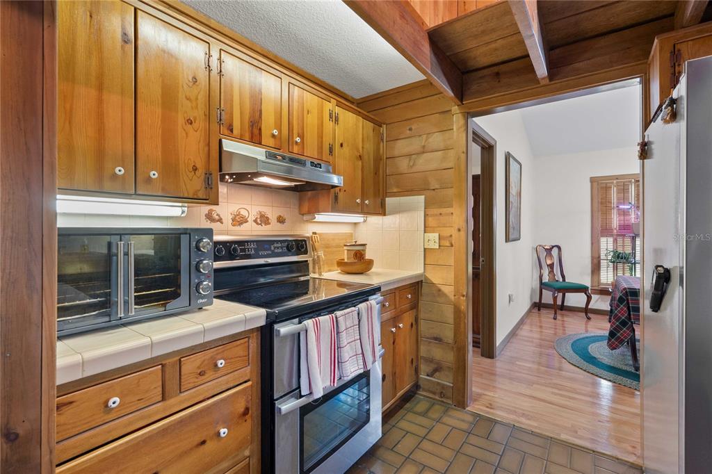 17055 Sweetwater Road Dade City, FL 33523 - Photo 25 of 53 a kitchen with granite countertop a stove and cabinets