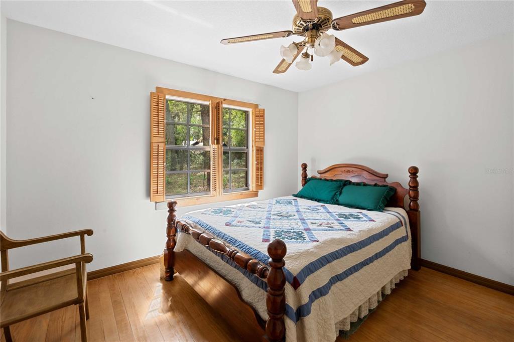 17055 Sweetwater Road Dade City, FL 33523 - Photo 33 of 53 a bed sitting in a bedroom next to a window