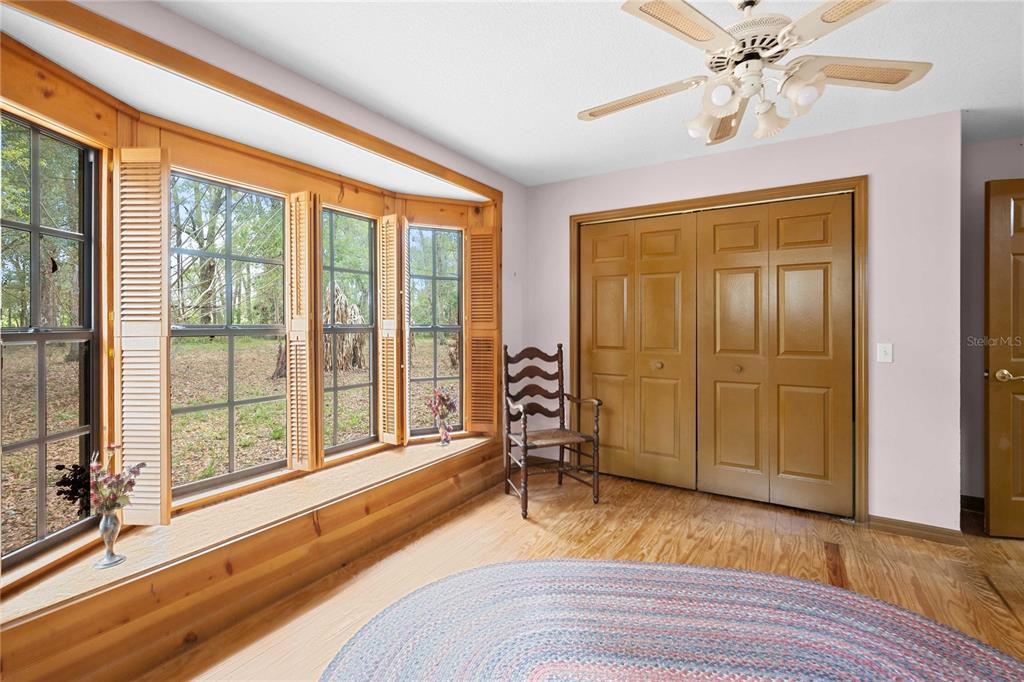 17055 Sweetwater Road Dade City, FL 33523 - Photo 35 of 53 a spacious bedroom with a large bed and a chandelier fan
